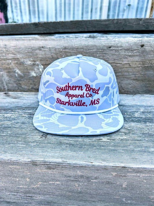 Light blue cap with red text on a wooden surface
