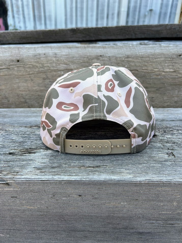 Camouflage-patterned cap on a wooden surface