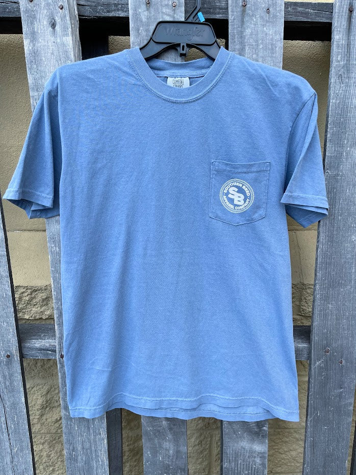 Blue Jean t-shirt with a White logo on a hanger against a wooden fence background