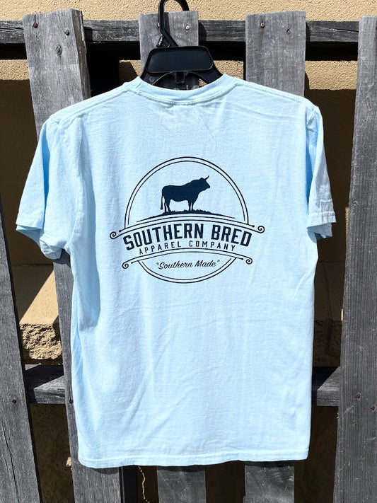 Light blue t-shirt with 'Southern Bred Apparel Company' Navy logo on a wooden background