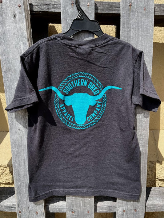Black t-shirt with teal graphic design on a wooden surface