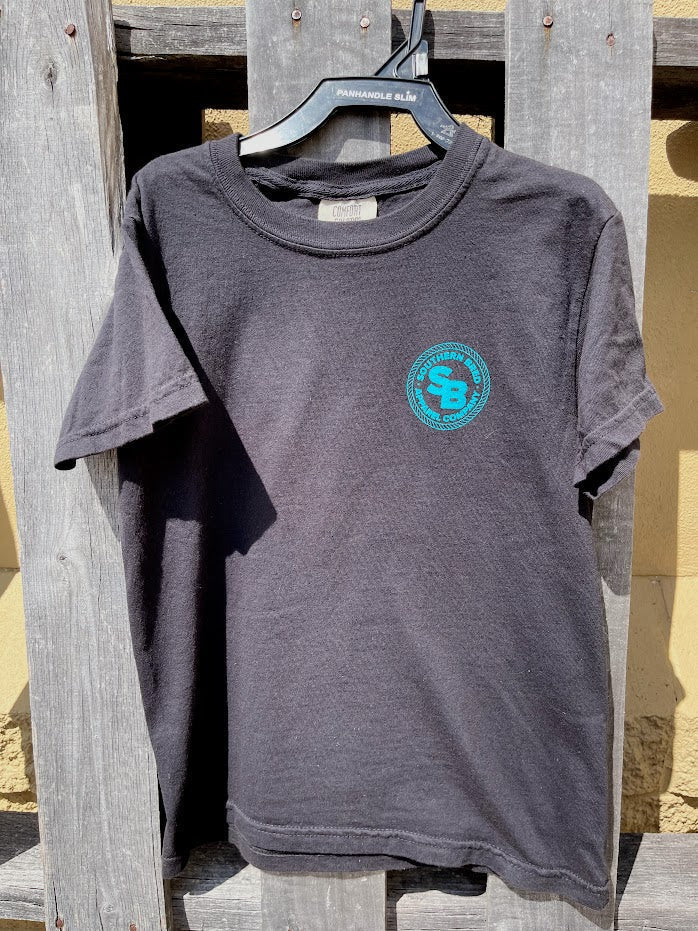 Black t-shirt with a Teal logo on a wooden surface